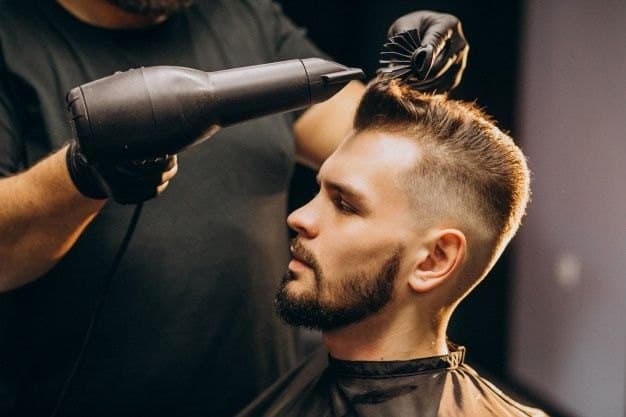 Queens barber blending a spring fade haircut with clippers