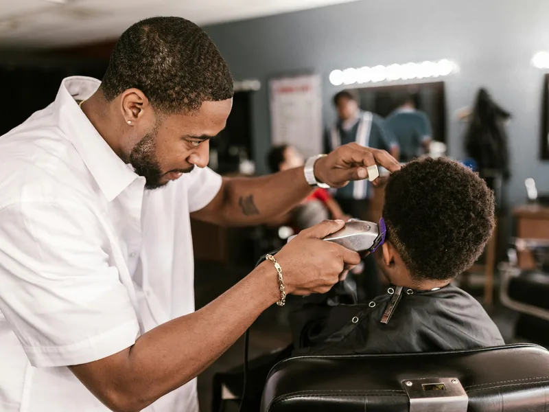 Professional barber cutting a men’s haircut in Queens